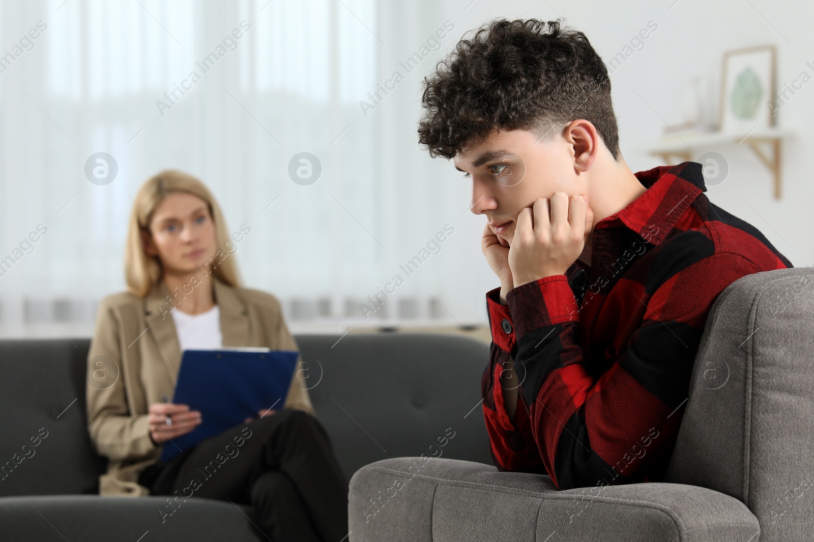 Photo of Psychologist working with teenage boy in office. Teenager problems