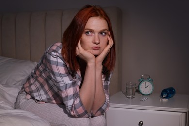 Woman suffering from insomnia on bed at home