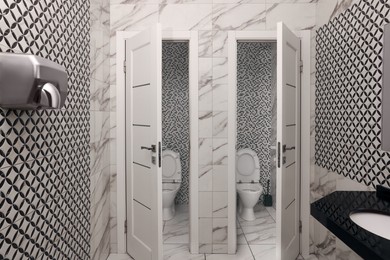 Photo of Public toilet interior with stylish white tiles