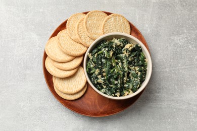 Photo of Tasty spinach dip with egg and crackers on grey table, top view