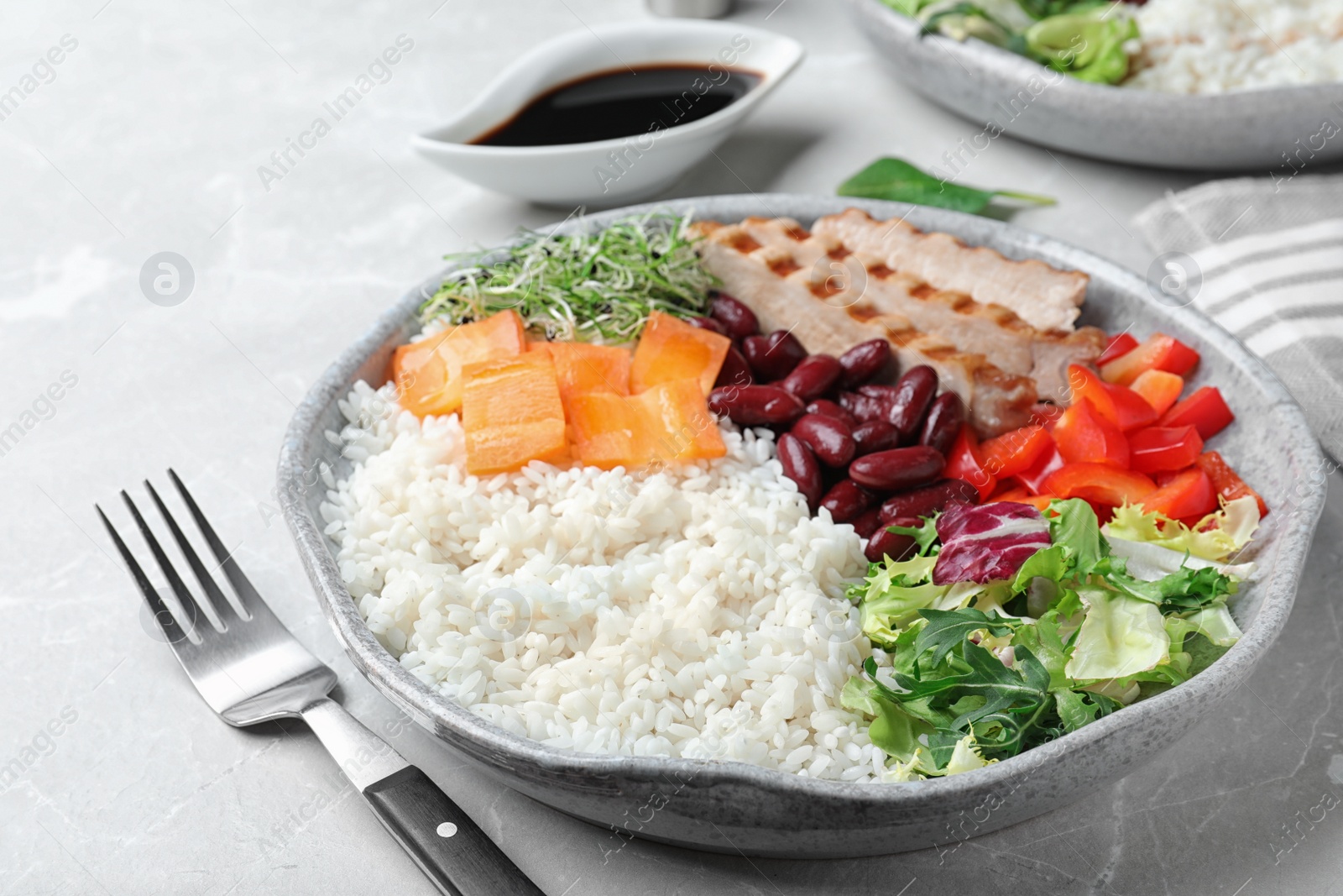 Photo of Tasty rice with beans and chicken meat on light grey marble table, closeup