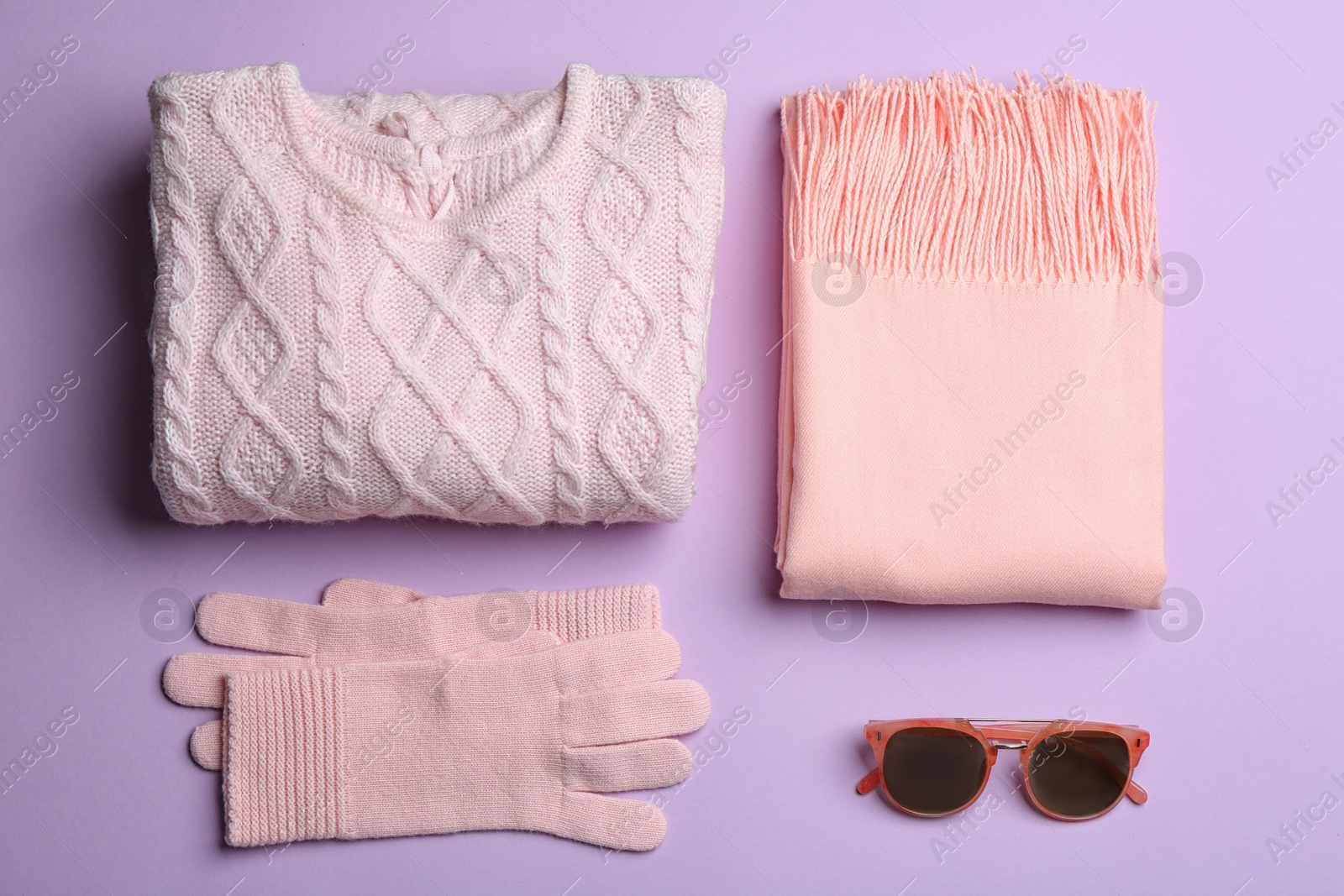 Photo of Flat lay composition with warm clothes on lilac background