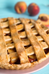 Delicious fresh peach pie on light blue wooden table, closeup