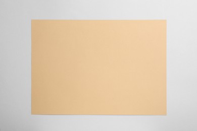 Sheet of brown paper on white background, top view