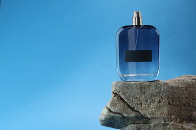 Stylish presentation of luxury men`s perfume on stone against light blue background. Space for text