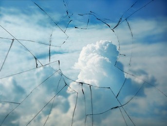 Image of View through broken window on cloudy sky