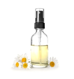 Bottle of herbal essential oil and chamomile flowers isolated on white