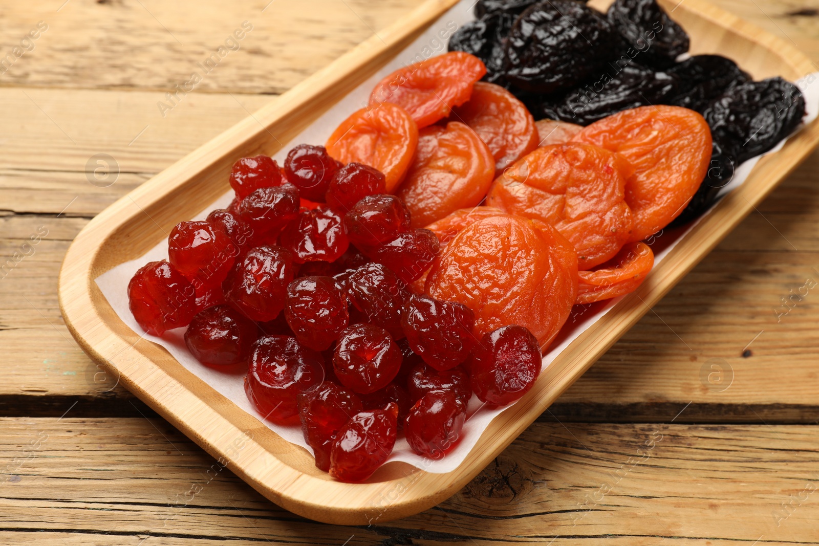 Photo of Delicious dried fruits on wooden table, closeup