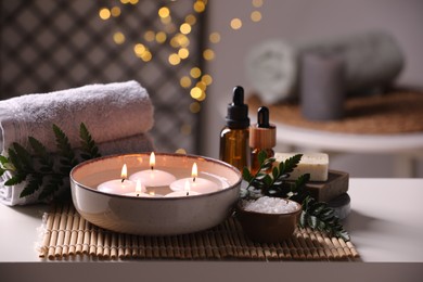 Beautiful composition with different spa products on table against blurred lights