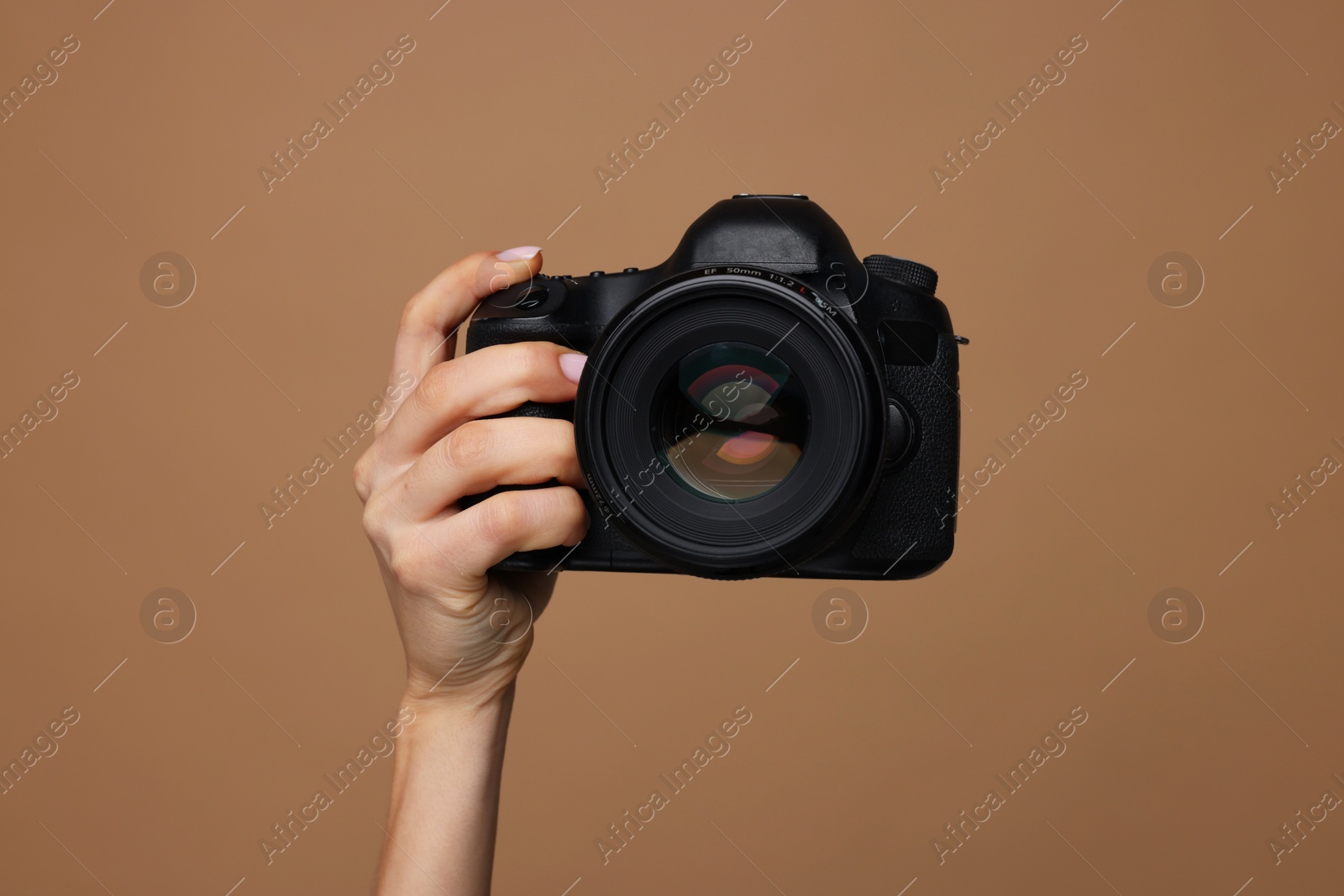 Photo of Photographer with camera on brown background, closeup