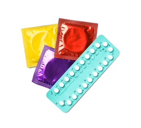 Condoms and birth control pills on white background, top view. Safe sex concept