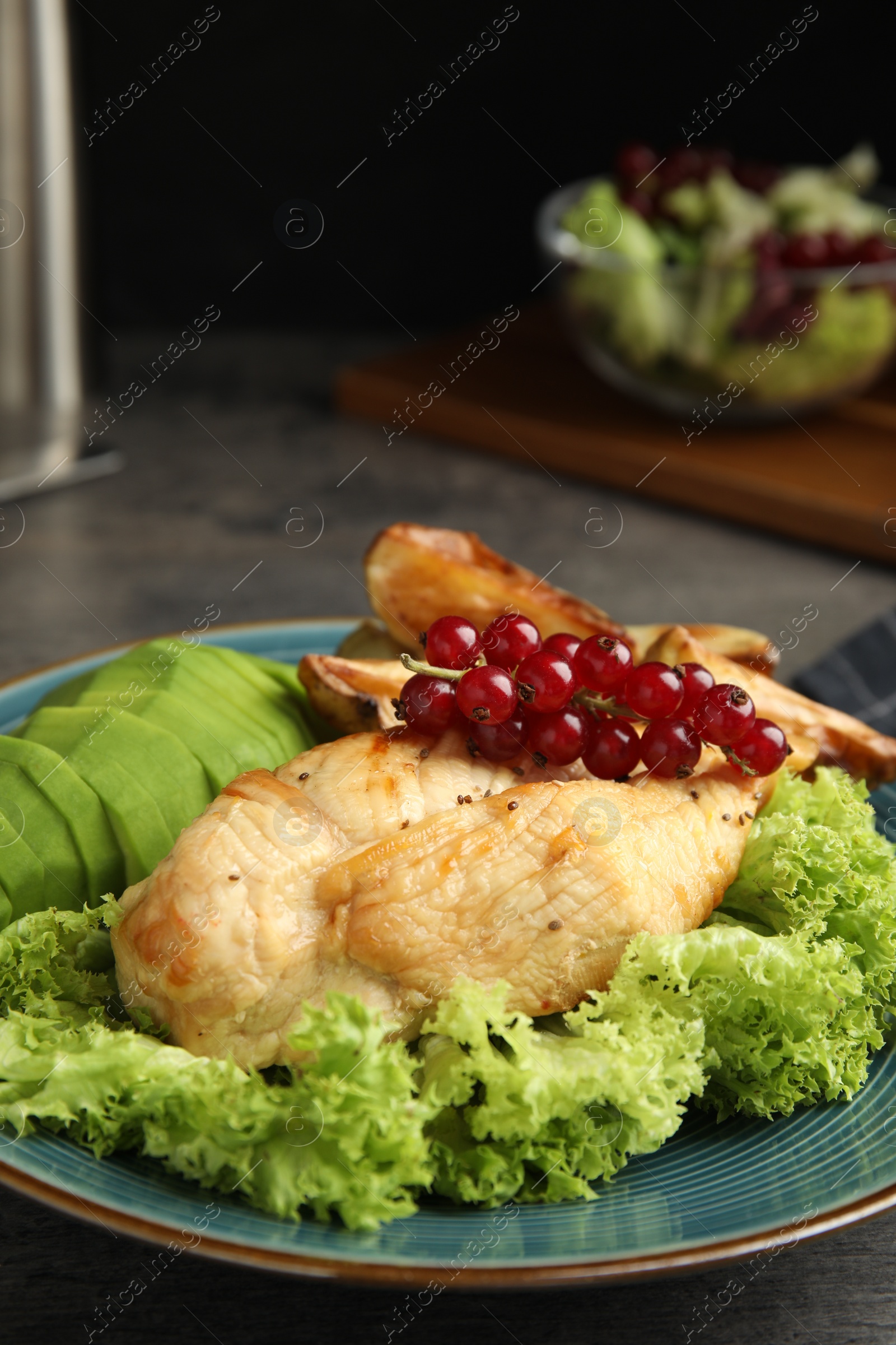 Photo of Tasty cooked chicken fillet and vegetables served on grey table. Healthy meals from air fryer