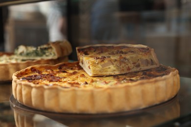 Photo of Delicious meat quiche on counter in bakery shop, closeup