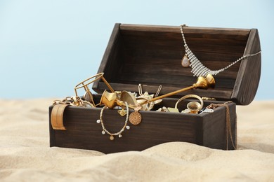 Photo of Open wooden treasure chest on sandy beach