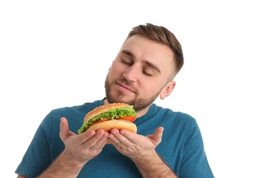 Young man with tasty burger on white background