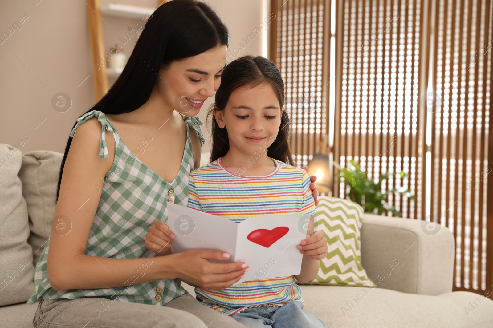 Photo of Little daughter congratulating her mom at home. Happy Mother's Day