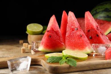 Photo of Tasty juicy watermelon, ice and lime slices on wooden table, space for text