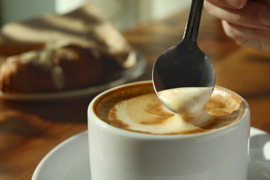 Cup of fresh aromatic coffee at table in cafe