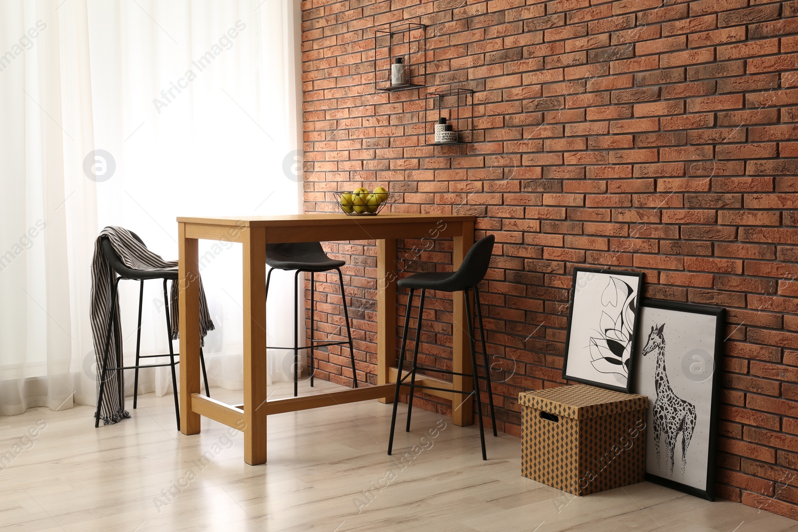 Photo of Elegant room interior with wooden table near brick wall