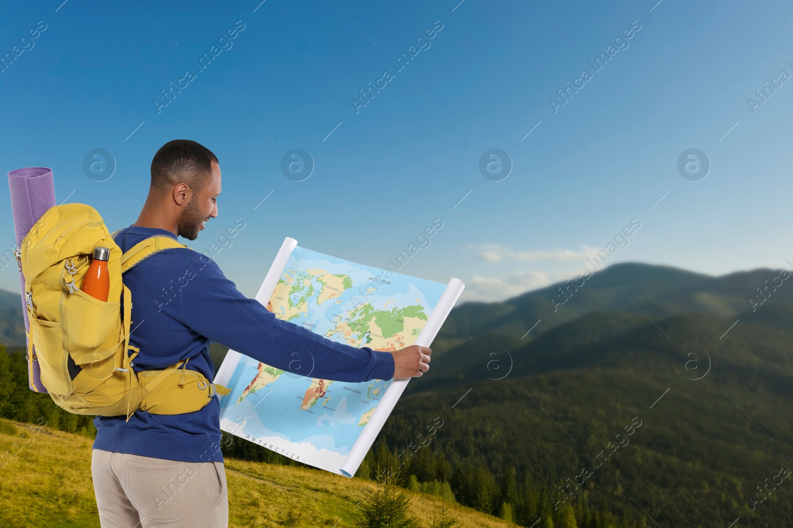 Image of Tourist with backpack and map in mountains