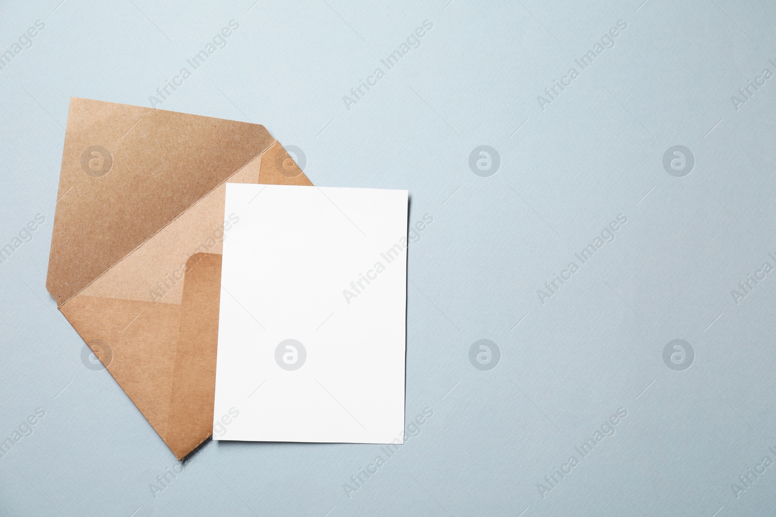 Photo of Letter envelope and card on grey background, top view. Space for text