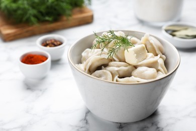 Photo of Tasty dumplings in bowl served on white marble table