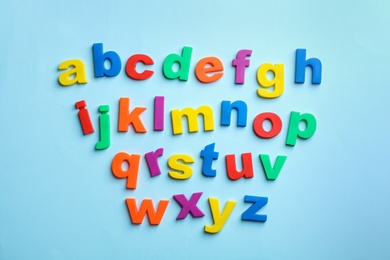 Photo of Plastic magnetic letters on color background, top view. Alphabetical order