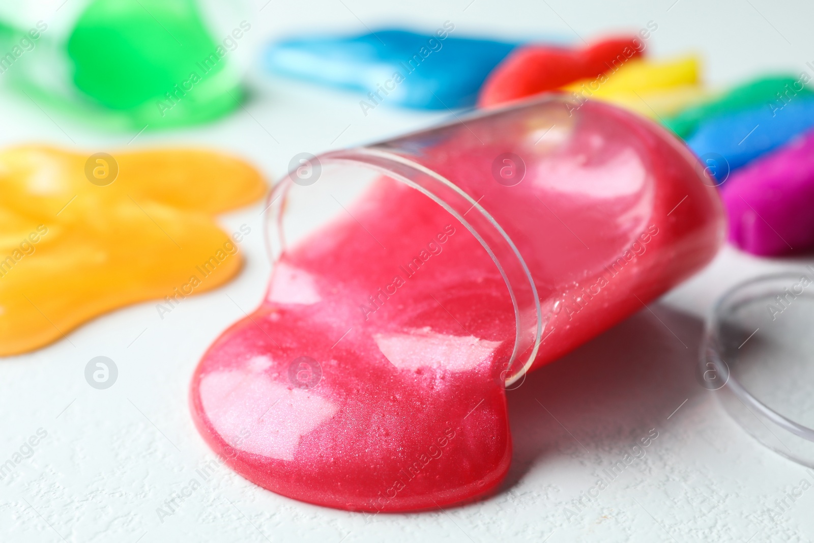 Photo of Different bright slimes on white background, closeup