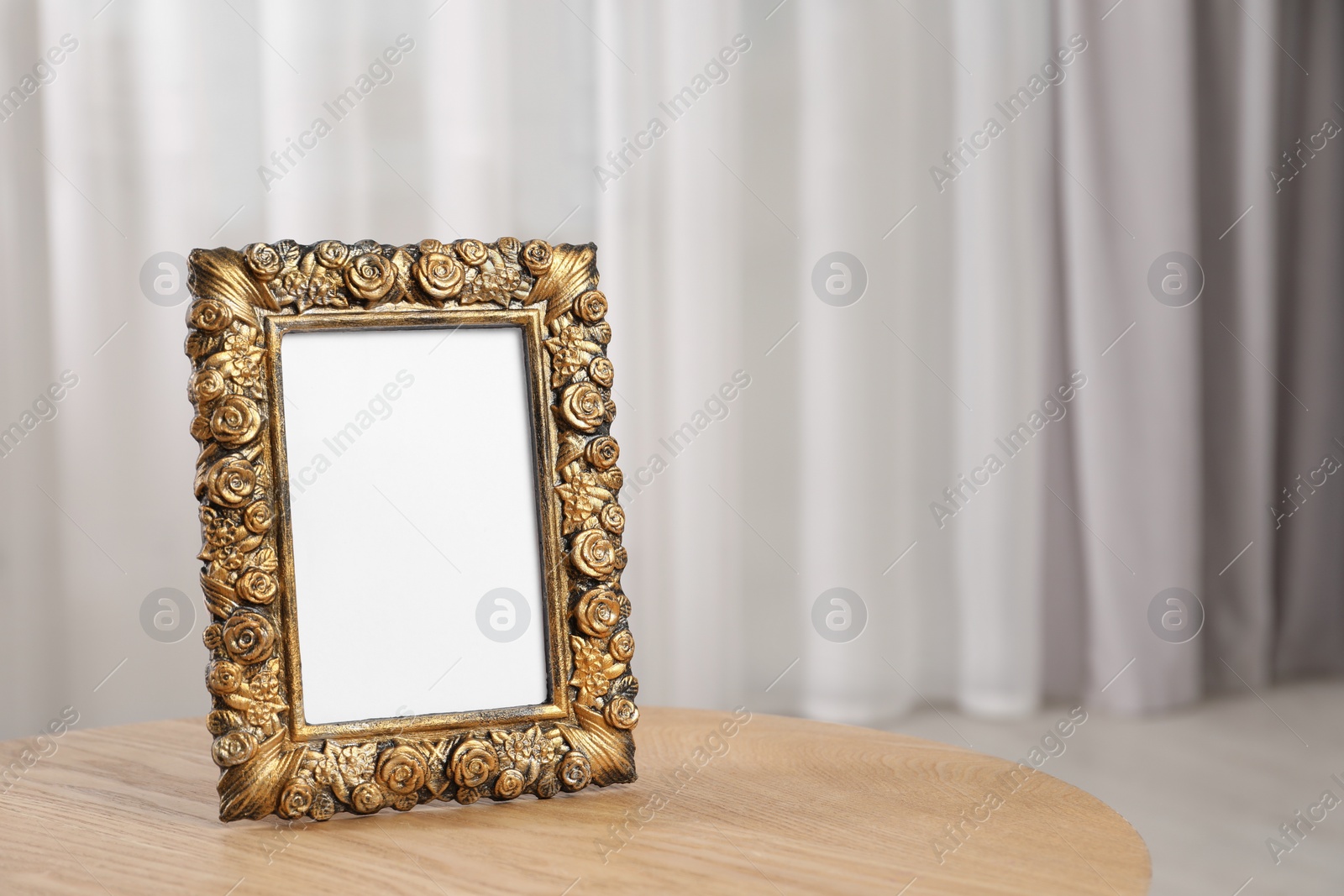 Photo of Empty photo frame on wooden table, space for text