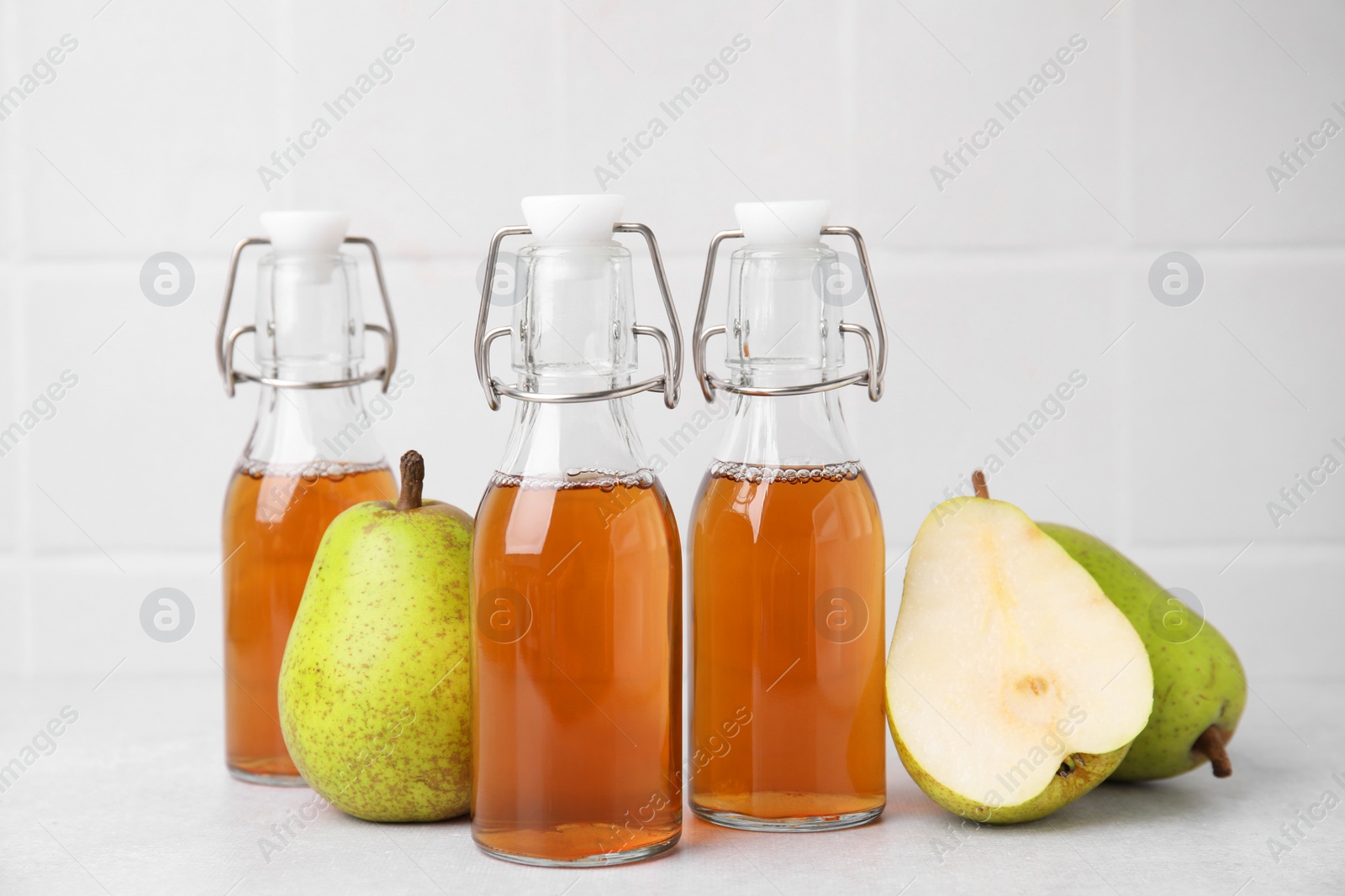 Photo of Tasty kombucha and pears on white table