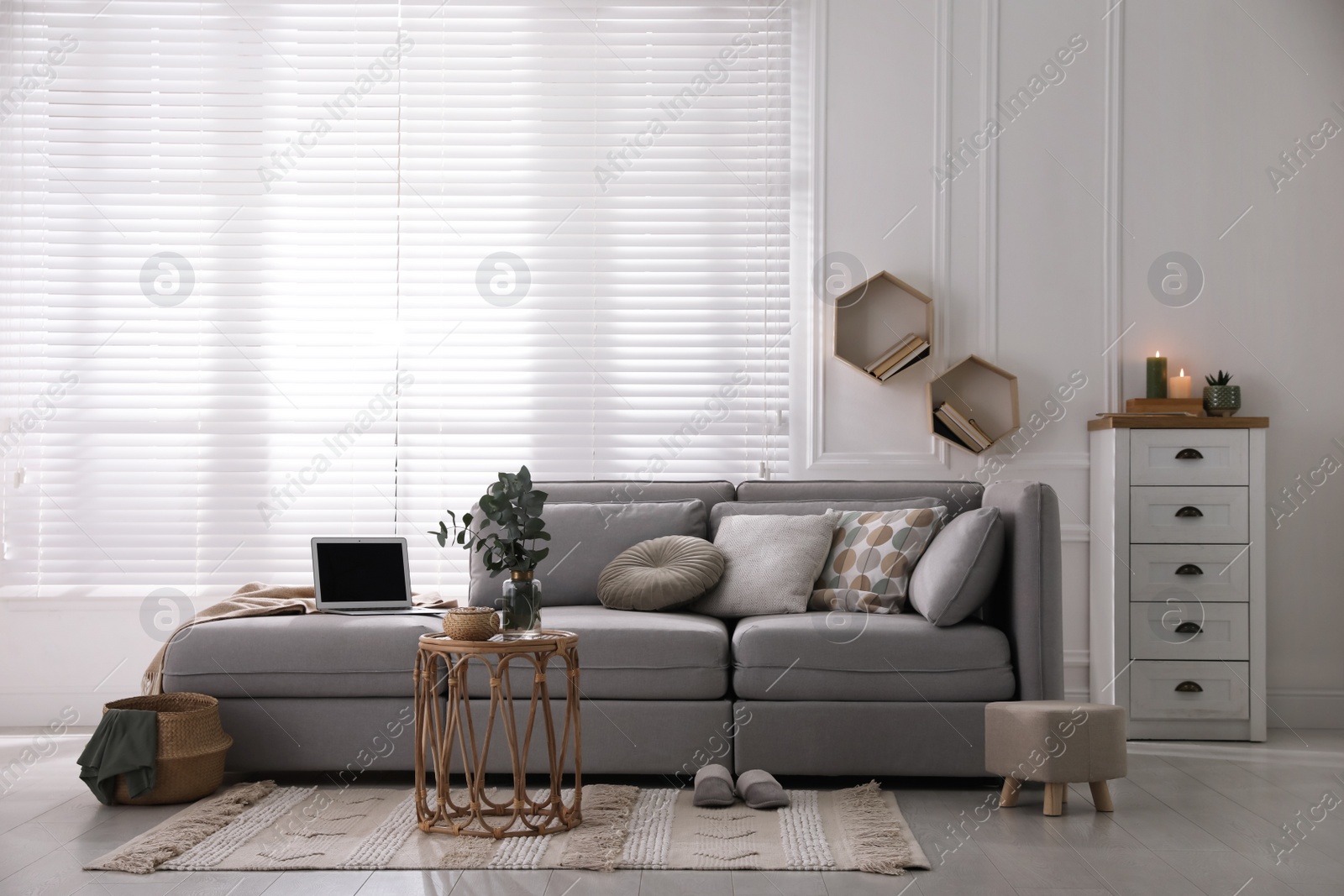 Photo of Living room with comfortable grey sofa and stylish interior elements near window