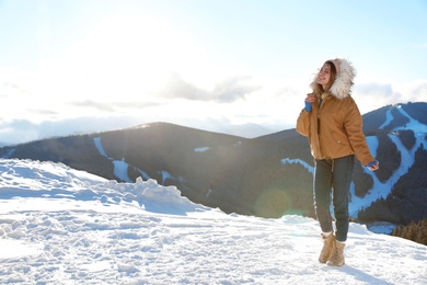 Photo of Happy young woman spending winter vacation in mountains. Space for text