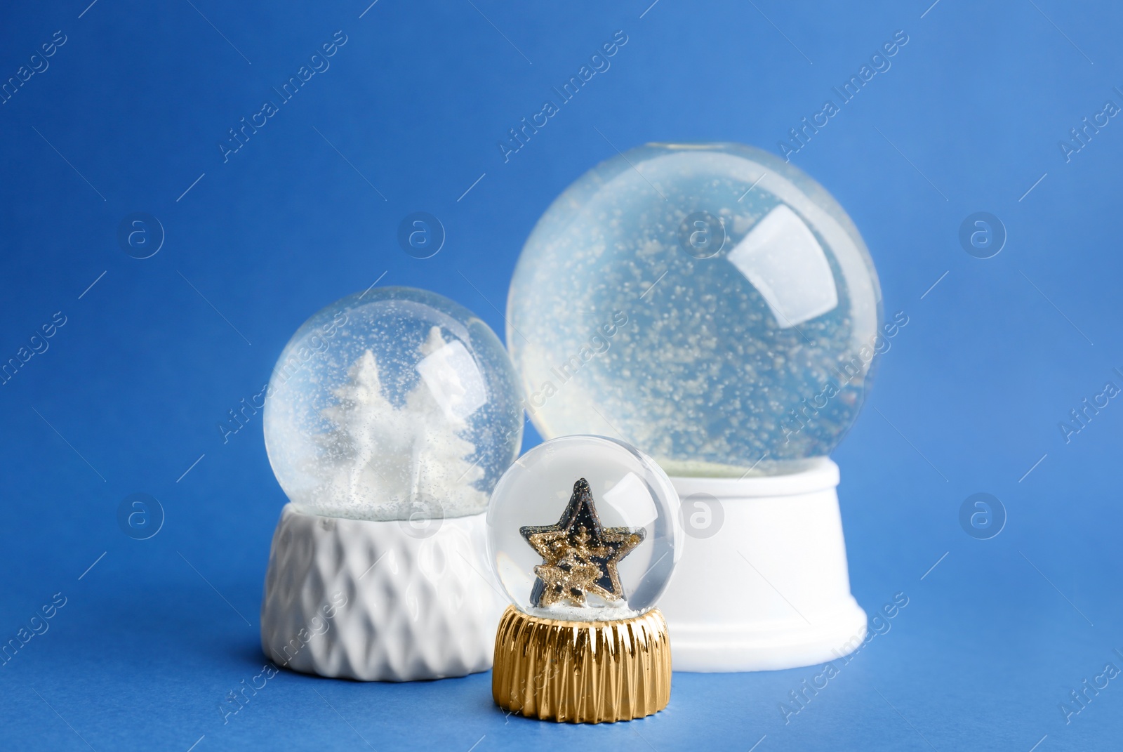 Photo of Different beautiful snow globes on blue background