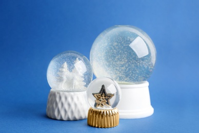 Different beautiful snow globes on blue background