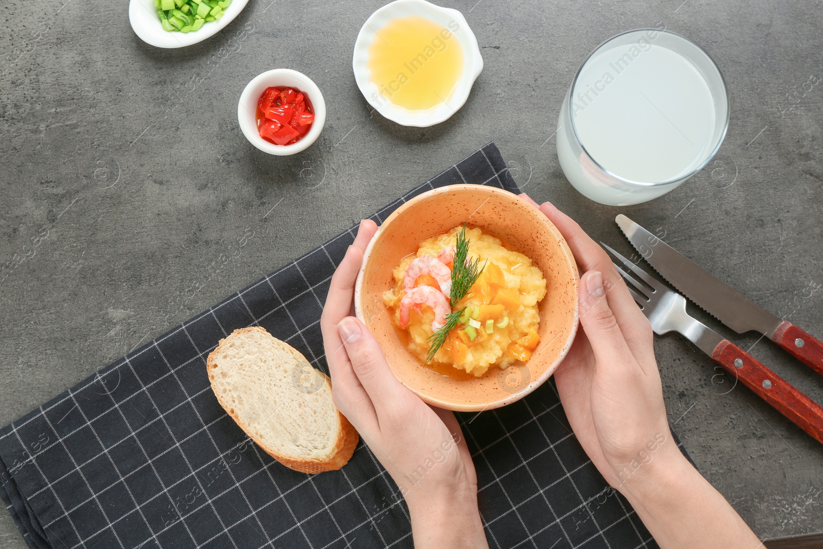 Photo of Woman with bowl of fresh tasty shrimp and grits on grey background