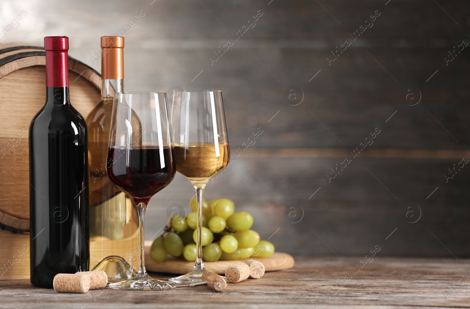 Photo of Composition with glasses and bottles of different wine on wooden table. Space for text