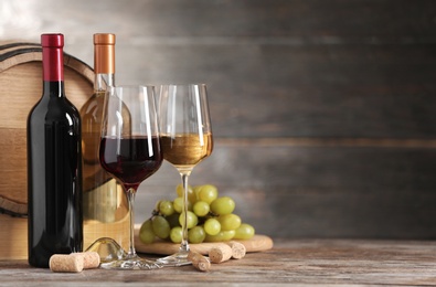 Photo of Composition with glasses and bottles of different wine on wooden table. Space for text