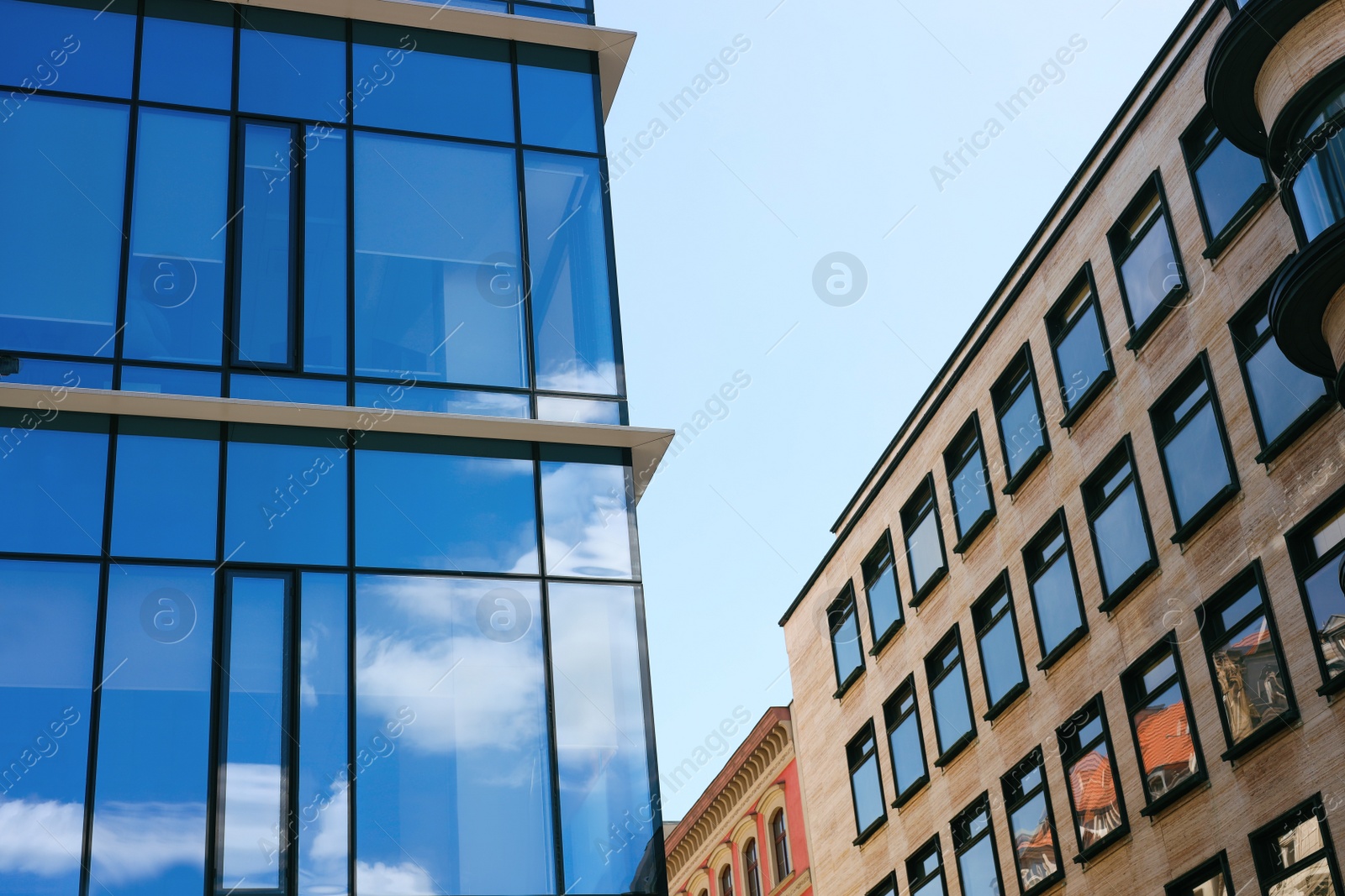 Photo of Low angle view of modern buildings against blue sky