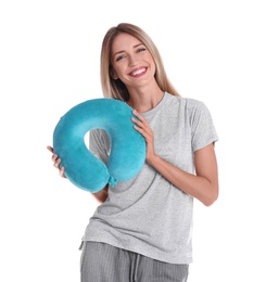 Happy young woman in pajamas with neck pillow on white background