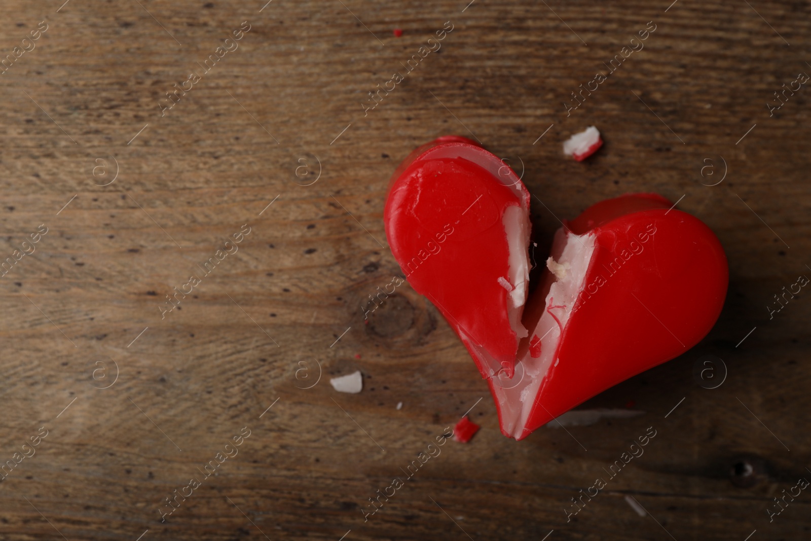 Photo of Broken heart shaped soap bar on wooden background, top view with space for text. Relationship problems concept