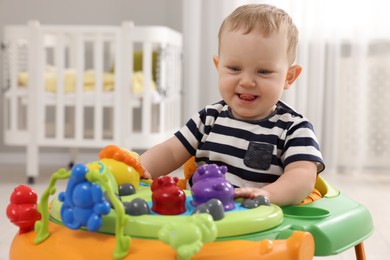 Photo of Portrait of cute baby with toy walker at home. Learning to walk