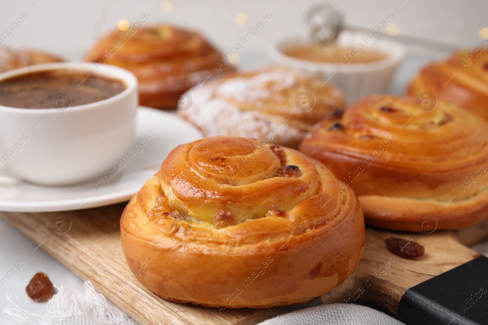 Photo of Delicious rolls with raisins on table, closeup. Sweet buns