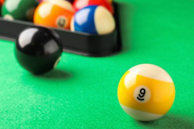 Photo of Billiard ball with number 9 on green table, closeup. Space for text
