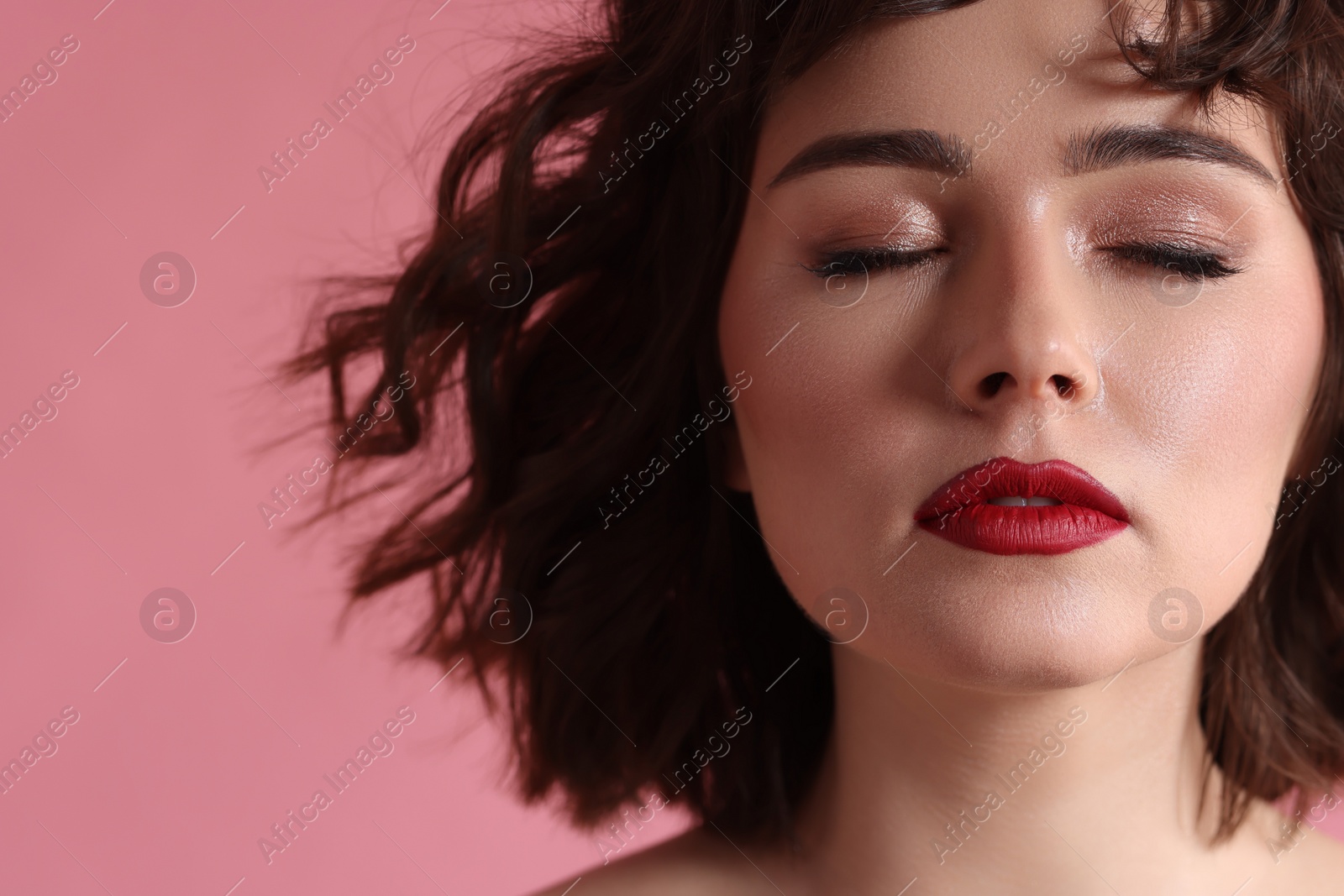 Photo of Beautiful young woman with wavy hairstyle on pink background. Space for text