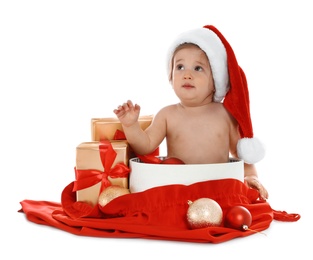 Photo of Cute little baby wearing Santa hat with Christmas gifts sitting in box on white background