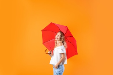 Photo of Woman with red umbrella on color background