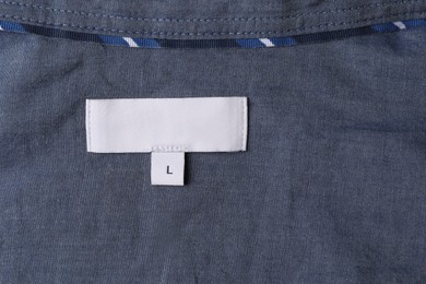 Photo of Clothing label on grey garment, top view