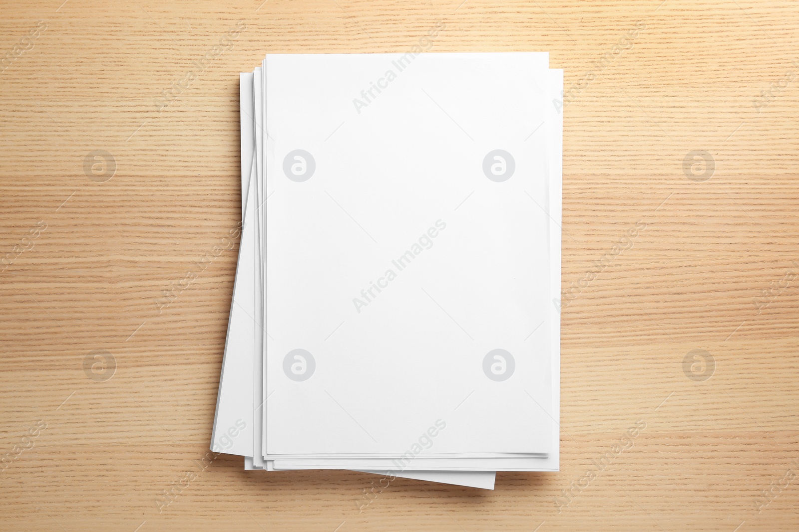 Photo of Stack of blank paper sheets for brochure on wooden background, top view. Mock up