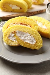 Delicious cake roll with cream filling on grey table, closeup