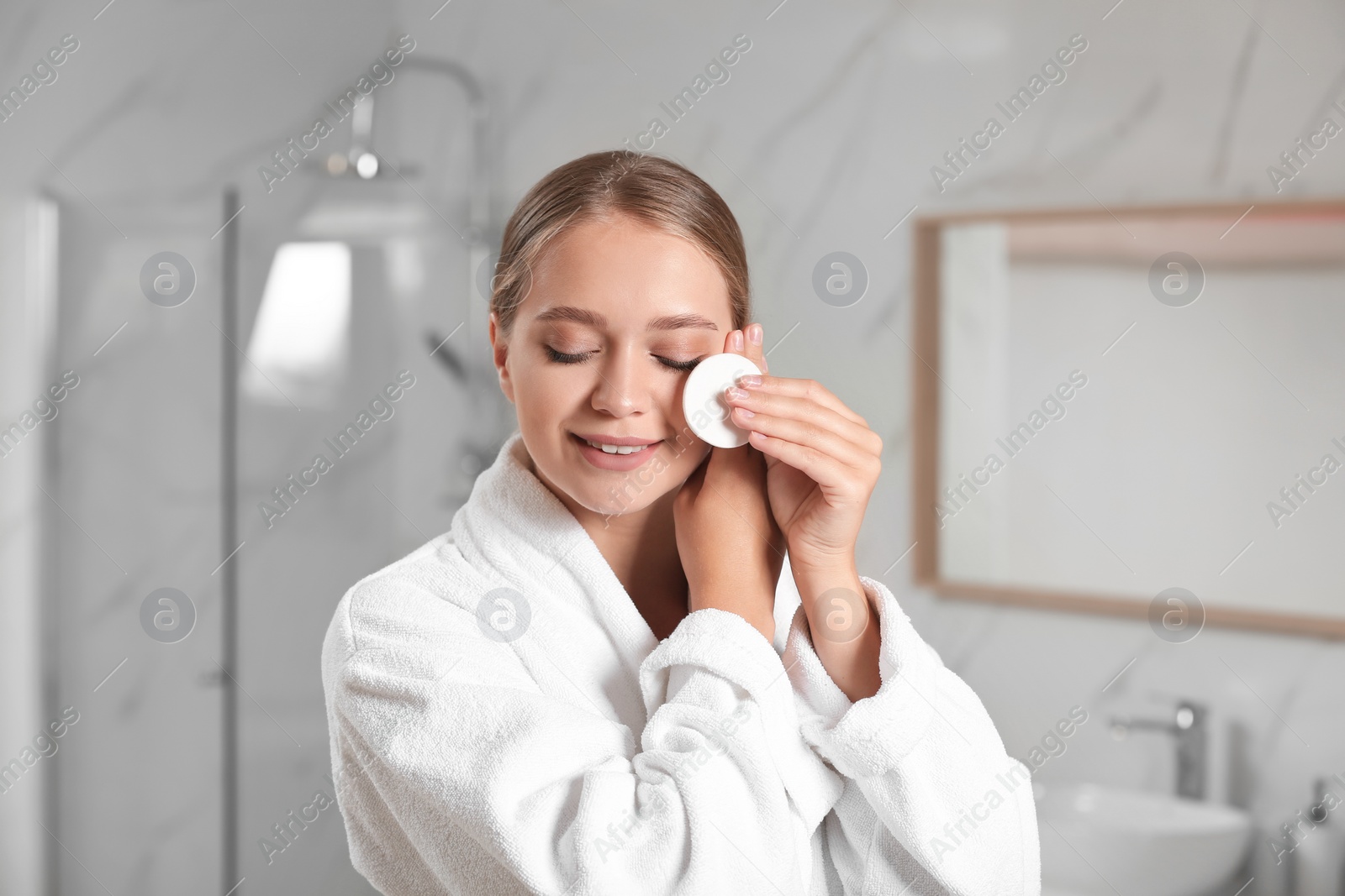 Photo of Beautiful young woman with cotton pad indoors